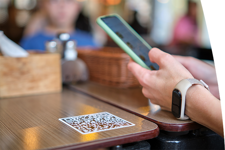 Closeup of guest hand ordering meal in restaurant while scanning qr code with mobile phone for online menu.